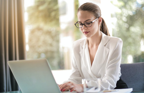 Young professional woman working at her laptop on bookkeeping services for her client. 